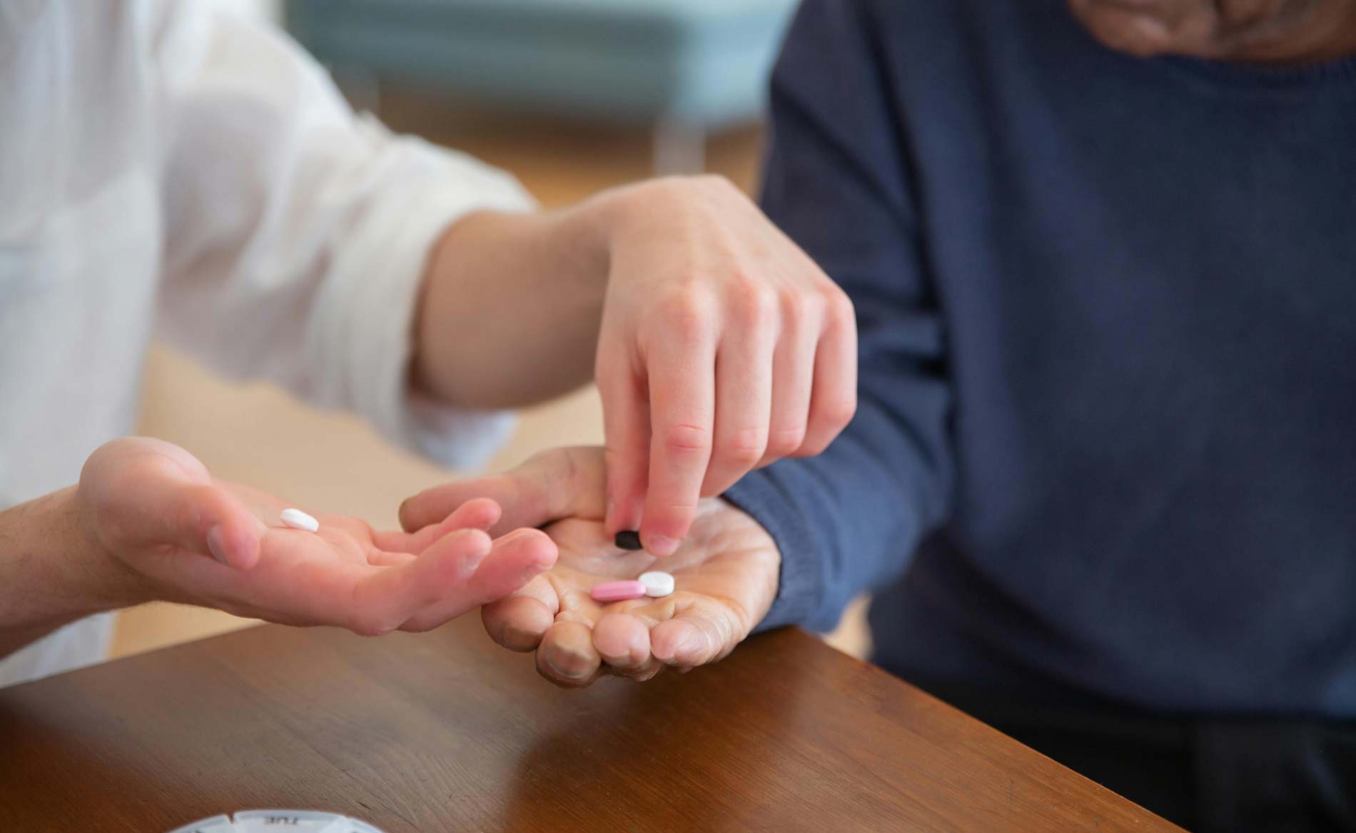 nursing care service - a health care staff giving prescription pills to a senior